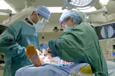 Two surgeons operating on a patient's leg